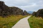 Thingvellir National Park, Iceland. Wooden boardwalk thorough landscape in park. Art Print